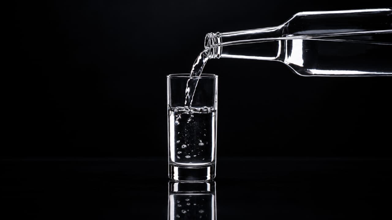 A person enjoying a drink of water outdoors