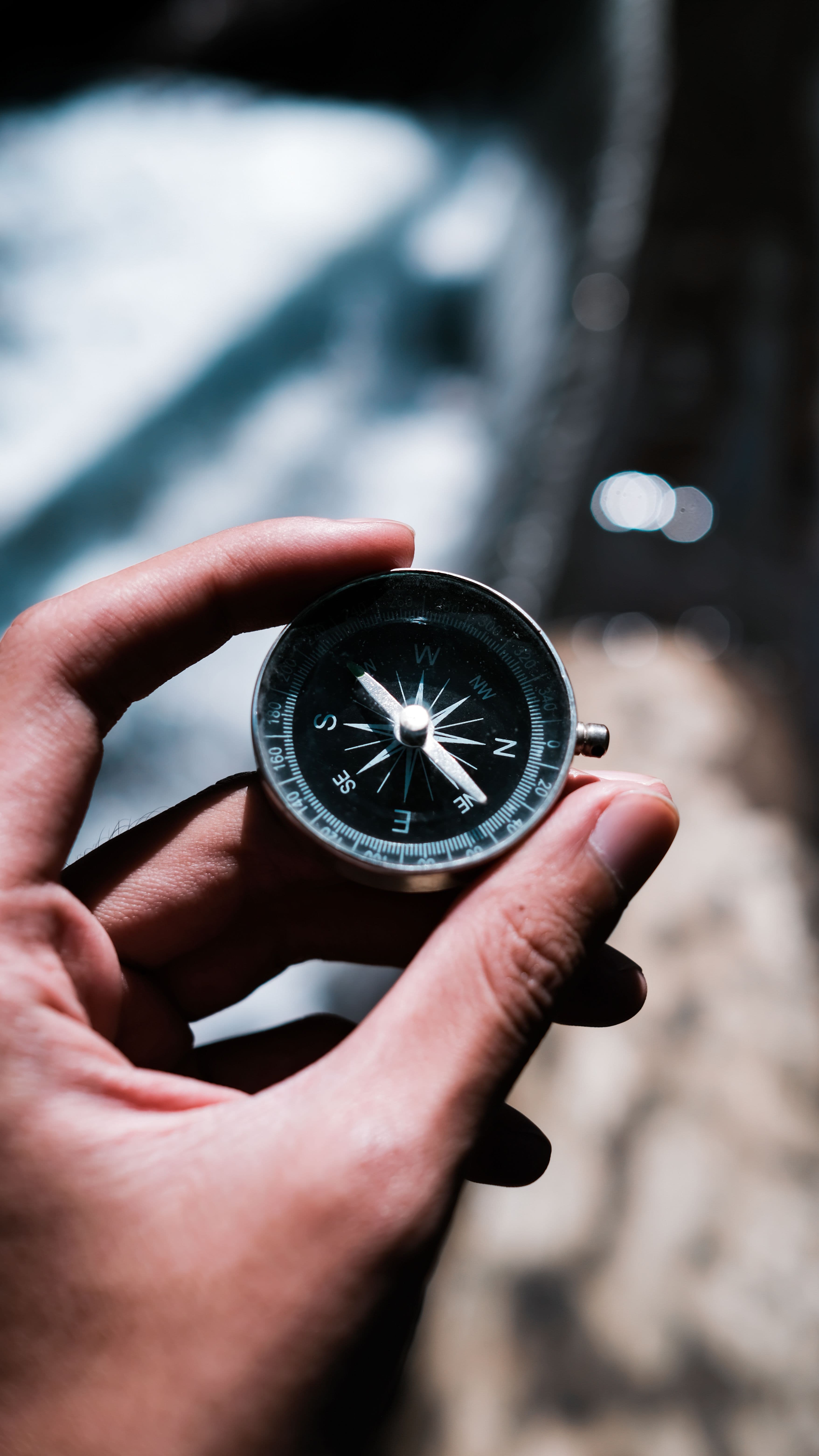 A hand holding a compass